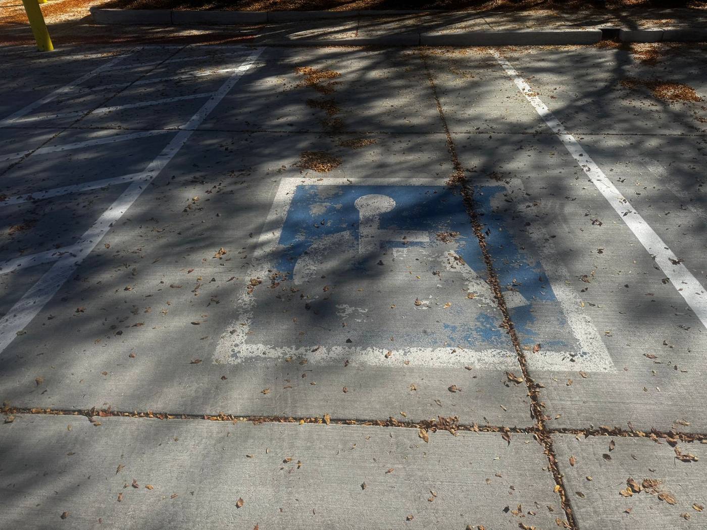 Faded accessible parking symbol before service